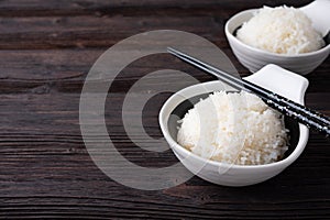 Bowl of boiled rice served on wooden table