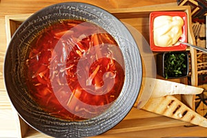 Bowl with borsch on wooden stand