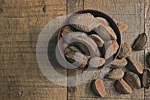 Bowl with Brazil nuts on wooden table. Space for text