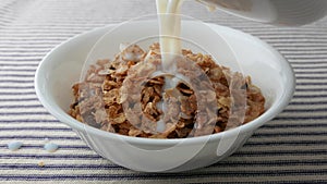 Bowl of breakfast cereal with skim milk being added