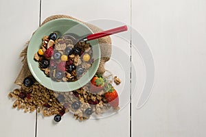 Bowl of breakfast cereals and fruits with spoon