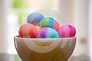 Bowl of brightly colored Easter eggs on diplay
