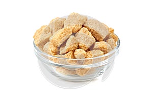 Bowl of brown cane sugar cubes on white