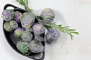 A Bowl of Brussels Sprouts with a sprig of Rosemary