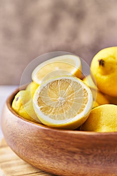 Bowl of bunch of lemons and halves on a marble surface