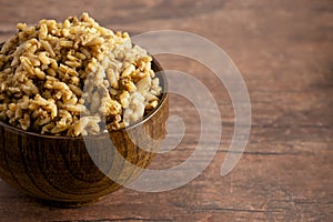 Bowl of Cajun Dirty Rice on a Rustic Wooden Table