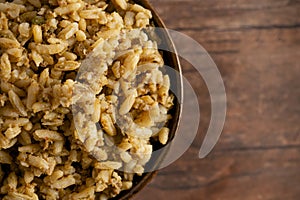 Bowl of Cajun Dirty Rice on a Rustic Wooden Table