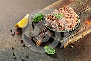 Bowl with canned Tuna on a wooden board. Food recipe background. Close up