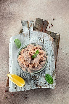 Bowl with canned Tuna on a wooden board. Food recipe background. Close up