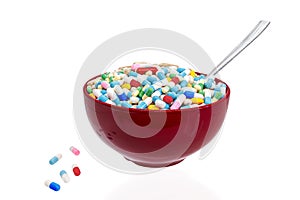 Bowl of capsules and pills with a spoon as concept of overmedication