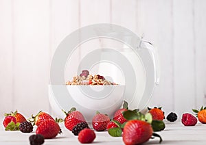 Bowl with cereal and fresh berries and jar of milk