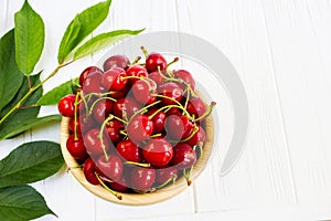 A bowl with cherrys on white table