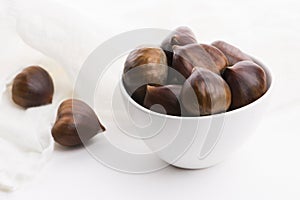 Bowl of chestnuts on a white background