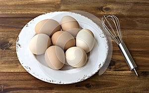 Bowl of chicken eggs, whisk.