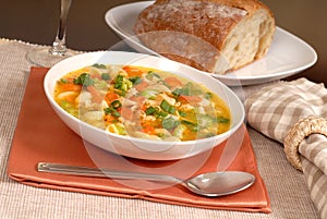 Bowl of chicken noodle soup with rustic bread