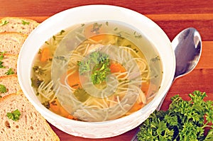 Bowl with chicken soup with vegetables and chicken meat, toasted bread