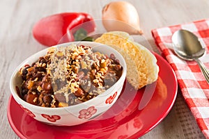 Bowl of Chili With Corn Bread Muffin And Vegetables