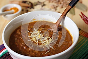 Bowl of Chili With Pinto Beans on Table With Peppers and Dry Beans in Background