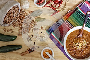 Bowl of Chili With Pinto Beans on Table With Peppers and Dry Beans in Background