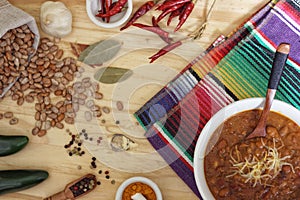 Bowl of Chili With Pinto Beans on Table With Peppers and Dry Beans in Background