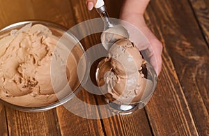 Bowl of chocolate ice cream scoops with pieces of chocolate bar
