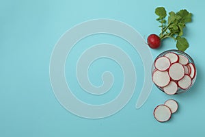 Bowl with chopped radish on blue background