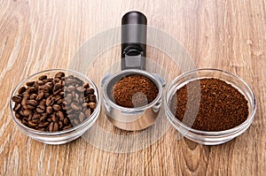 Bowl with coffee beans, holder of coffee maker with ground coffee, bowl with coffee on table