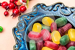 Bowl with colorful caramels, lollipops for resorption with fruit flavors