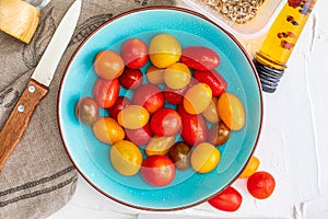 Bowl of colorful cherry tomatoes red, garnet and yellow, fresh and raw. With water drops Homemade appearance with olive oil and