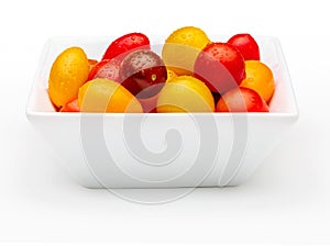 Bowl of colorful cherry tomatoes red, garnet and yellow, fresh and raw. With water drops Isolated on white background