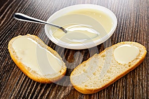 Bowl with condensed milk, slices of bun poured milk on wooden table