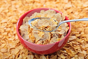 Bowl with corn flakes on corn flakes background photo