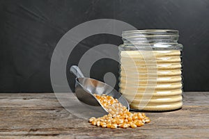 Bowl with corn flour and kernels on table.