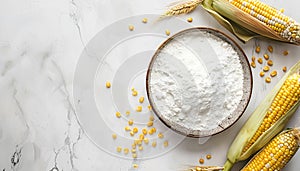 Bowl with corn starch, ripe cobs and kernels on white table