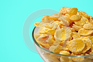 A bowl of cornflakes on a blue background. Close-up