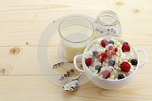 Bowl with cottage cheese and fresh berries on wooden table