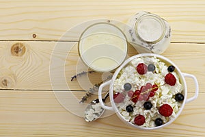 Bowl with cottage cheese and fresh berries on wooden table