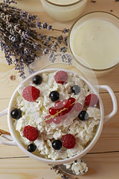 Bowl with cottage cheese and fresh berries on wooden table