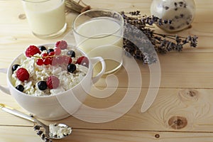 Bowl with cottage cheese and fresh berries on wooden table