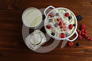 Bowl with cottage cheese and fresh berries on wooden table