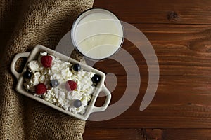 Bowl with cottage cheese and fresh berries on wooden table