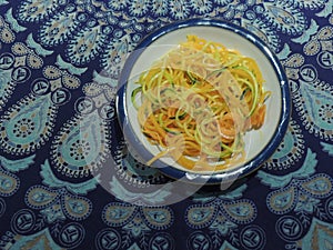 Bowl of courgette noodles zucchini courgetti butternut squash white bowl mandala tablecloth