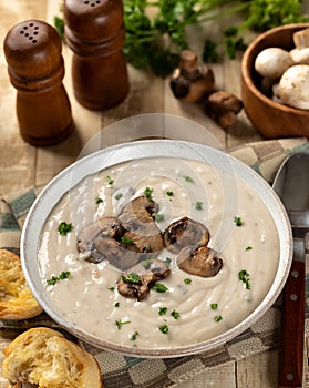 Bowl of creamy mushroom soup with sliced mushrooms and parsley