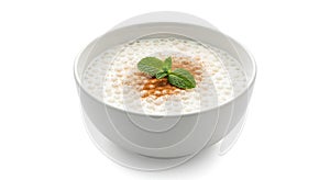 Bowl of creamy tapioca pudding with cinnamon and mint leaf on white background