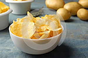 Bowl of crispy potato chips on table