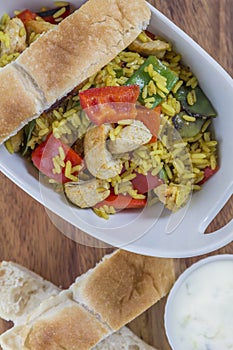 Bowl with curry flavored rice chicken and vegetables