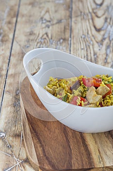 Bowl with curry flavored rice chicken and vegetables