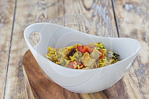 Bowl with curry flavored rice chicken and vegetables