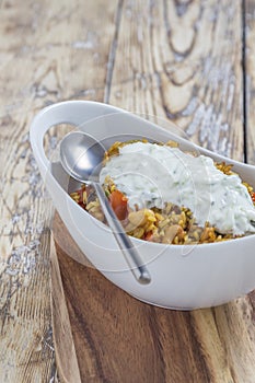 Bowl with curry flavored rice chicken and vegetables