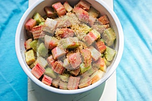 Bowl with cut rhubarb and golden sugar